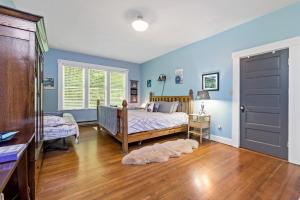 a bedroom with blue walls and a bed and a window at Mountain Meadows Inn & Chalet Suites in Ashford
