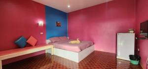 a bedroom with pink and blue walls and a bed at Phuttharaksa Resort in Ko Larn