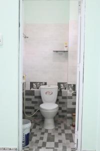 a bathroom with a toilet and a tile floor at Mộc Coffee - Hotel in Quang Ngai