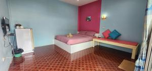 a small room with a bed and a bench at Phuttharaksa Resort in Ko Larn