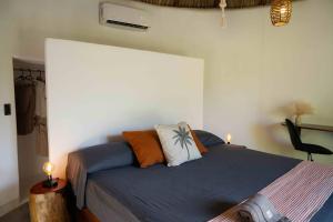 a bedroom with a bed with two pillows on it at Casa MexiBali, Palapita in Troncones