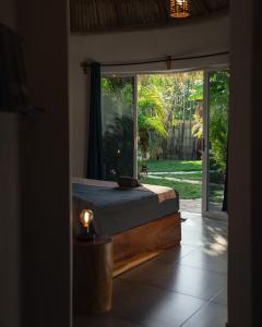 um quarto com uma cama e uma grande janela em Casa MexiBali, Palapa 47 em Troncones