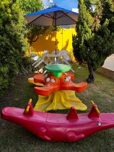 a toy inflatable boat with a table and an umbrella at Pousada Acalanto in Aracaju