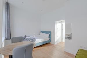 a bedroom with a bed and a wooden table at HAFH in Paddington - Double studio 1 in London