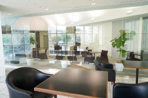 uma sala de conferências com mesas, cadeiras e plantas em Chateraise Hotel Nagano em Nagano