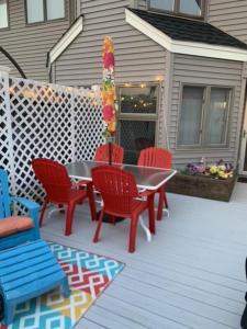 eine Terrasse mit roten Stühlen und einem Tisch mit einer Stange in der Unterkunft Brant Beach 2 Bedroom 1 Bath Ocean Side Condo in Brighton Beach