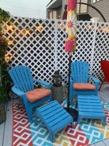 zwei blaue Stühle und ein Regenschirm auf einer Terrasse in der Unterkunft Brant Beach 2 Bedroom 1 Bath Ocean Side Condo in Brighton Beach