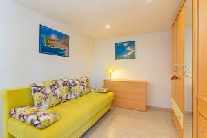 a yellow couch in a living room with a lamp at Apartments Mici 1 - great location and relaxing in Cres
