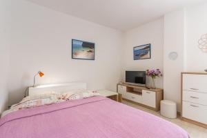 茨雷斯的住宿－Apartment Mici 2 - great loaction and relaxing，一间卧室配有粉红色的床和电视