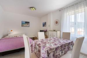a bedroom with a bed and a table and chairs at Apartment Mici 2 - great loaction and relaxing in Cres