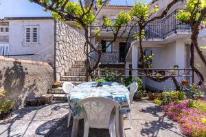 a table and chairs in front of a house at Apartment Mici 2 - great loaction and relaxing in Cres