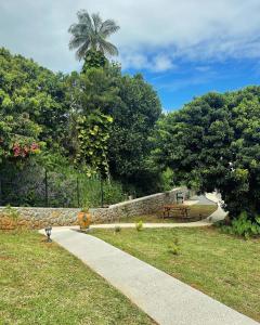 un parco con panchina e muro di pietra di Austral House-chalet sud sauvage a Saint-Joseph