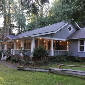 a house with a front porch with lights on at Mountain Meadows Inn & Chalet Suites in Ashford