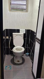 Camera piastrellata dotata di bagno con servizi igienici bianchi. di Homestay D'Lempor 