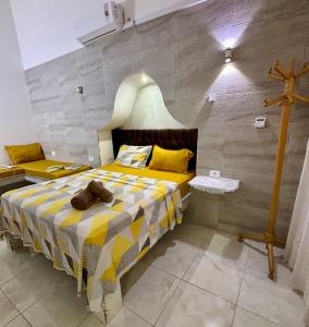 ein Schlafzimmer mit einem Bett mit einem Kreuz an der Wand in der Unterkunft MAHDIA BORJ ERRAS (CAP AFRICA) in Mahdia
