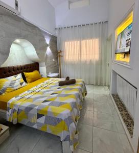 a bedroom with a bed with a yellow and gray blanket at MAHDIA BORJ ERRAS (CAP AFRICA) in Mahdia