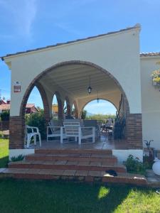 eine Terrasse mit einer Laube, Tischen und Stühlen in der Unterkunft Alleinstehende Villa mit Pool-Finca Gabriela in Oliva