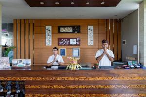 two men sitting at a counter in a restaurant with their hands up at Asa Bali Luxury Villas & Spa in Seminyak