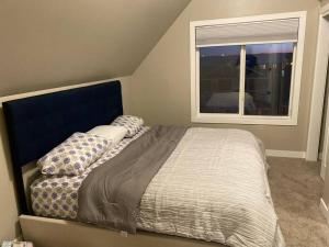 a bedroom with a bed with pillows and a window at 3 BDR - Bonus Room - King Bed - Garage - Near Airport in Regina