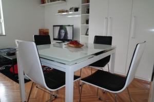 een witte tafel met stoelen en een fruitschaal erop bij Apartment Penny in Split
