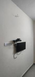 a white wall with a remote control on it at Kingdom of dorms-the shared room in Chennai