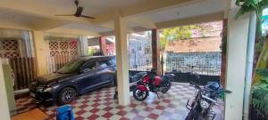 a car parked in a garage next to a motorcycle at Kingdom of dorms-the shared room in Chennai