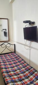 a bedroom with a bed with a tv on the wall at Kingdom of dorms-the shared room in Chennai