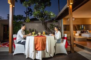 a man and a woman sitting at a table at Asa Bali Luxury Villas & Spa in Seminyak