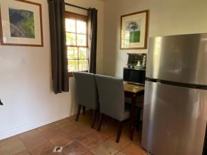 a kitchen with a table and a stainless steel refrigerator at TIDE POOL VILLAS in Santa Barbara