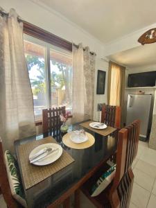 a dining room with a table and chairs and a kitchen at Panagsama Holiday Cottage in Moalboal