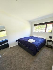 1 dormitorio con cama azul y espejo en New and Fabulous, City Fringe Bliss! en Wellington