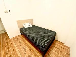 a bed with a pillow on top of it in a room at Kasmarani Homestay in Palembang