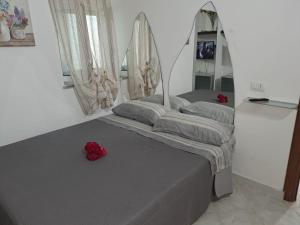 twee bedden in een kamer met rode rozen erop bij Appartamento con giardino in Civitavecchia