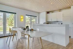 uma cozinha e sala de jantar com uma mesa branca e cadeiras em Relaxing Vacation In Scenic Surroundings em Højby