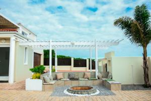 a patio with a fire pit and a white pergola at Santareme Seaviews in St Francis Bay