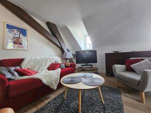 - un salon avec un canapé rouge et une table dans l'établissement Appartement hyper centre 6 pers., à Chamonix-Mont-Blanc