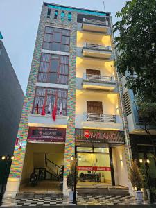 a tall white building with two floors and a store at Milano Hotel in Hải Dương