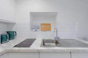 eine weiße Küche mit einer Spüle und einem Herd in der Unterkunft HAFH in Paddington - Double studio 3 in London