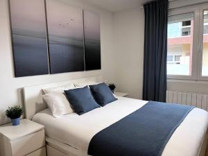 1 dormitorio con 1 cama grande con almohadas azules en Duplex con terraza en Renedo de Piélagos