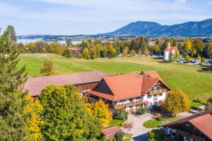 eine Luftansicht eines Hauses mit einem Feld und Bäumen in der Unterkunft Ferienhof AllgäuMax in Füssen