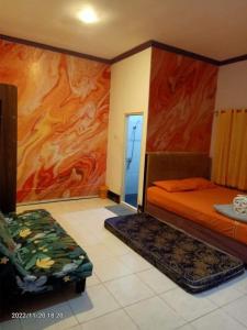 1 dormitorio con 1 cama y una pintura en la pared en Pavillion EMWEKA Balikpapan, en Balikpapan