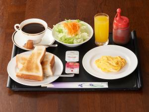 富士的住宿－Tabist Hotel New Central，盘子,盘子上放着早餐食品和咖啡