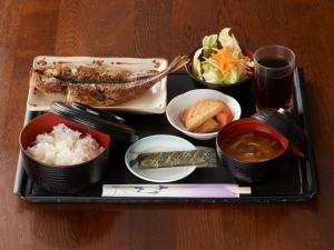 富士的住宿－Tabist Hotel New Central，桌上放有米饭和蔬菜的托盘