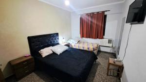 Dormitorio pequeño con cama y TV en Dpto amplio de categoria en Tucumán en San Miguel de Tucumán