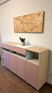 a pink desk with a potted plant on top at Dpto amplio de categoria en Tucumán in San Miguel de Tucumán