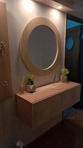 a bathroom with a vanity with a mirror and potted plants at Dpto amplio de categoria en Tucumán in San Miguel de Tucumán