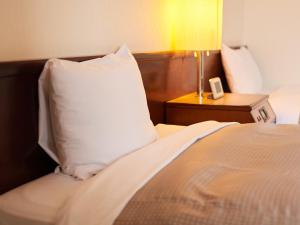 Una cama o camas en una habitación de Tabist Hotel New Central