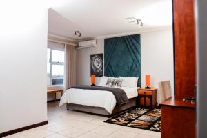 a bedroom with a bed and a large window at Santareme Seaviews in St Francis Bay