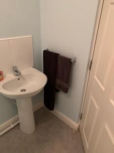 uma casa de banho com um lavatório branco e uma toalha preta em Spar Court One bed apartment em Burton upon Trent