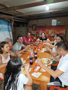 Un gruppo di persone seduti intorno a un tavolo che mangiano cibo di El Kachi Hospedaje y Restaurante a Uribia